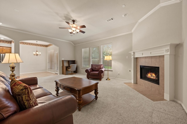 103 Deer Ct, Mansfield, TX 76063 - living room featuring a tiled fireplace, light carpet, ornamental molding, a ceiling fan, and arched walkways