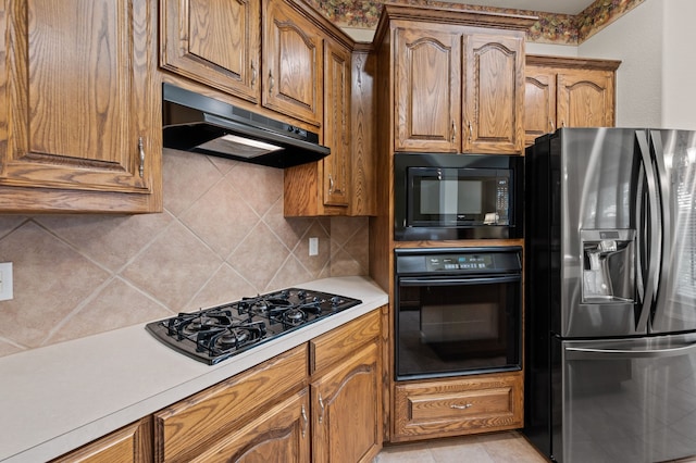 103 Deer Ct, Mansfield, TX 76063 - kitchen with black appliances, under cabinet range hood, light countertops, tasteful backsplash, and brown cabinetry