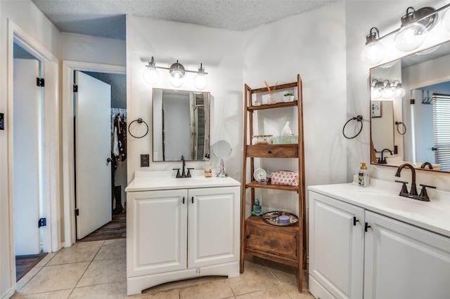 2407 Northlake Ct, Irving, TX 75038 - bathroom featuring two vanities, tile patterned floors, and a textured ceiling