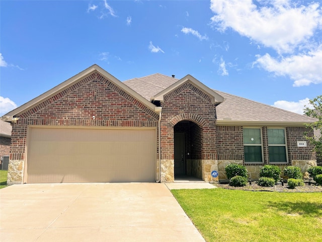 255 Carolina Trce, Fate, TX 75189 - view of front facade with brick siding, a shingled roof, a garage, concrete driveway, and a front lawn
