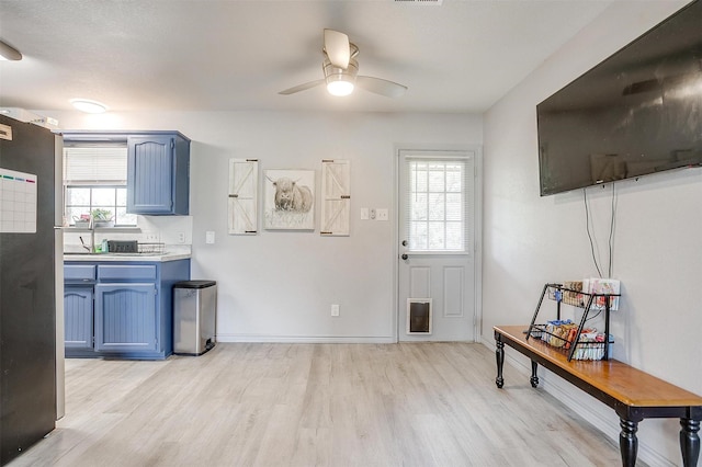 397 Flat Rock Rd, Azle, TX 76020 - kitchen with blue cabinets, light wood-style floors, a ceiling fan, and light countertops