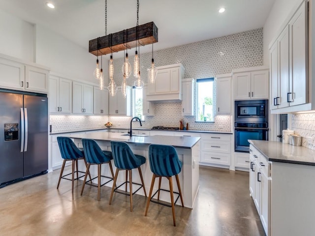 641 Cox Rd, Waxahachie, TX 75167 - kitchen featuring stainless steel appliances, finished concrete floors, tasteful backsplash, white cabinetry, and a breakfast bar