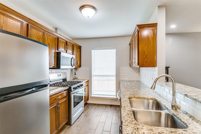 2019 Mcbroom St, Dallas, TX 75212 - kitchen with stainless steel appliances, brown cabinetry, light wood-style floors, and tasteful backsplash