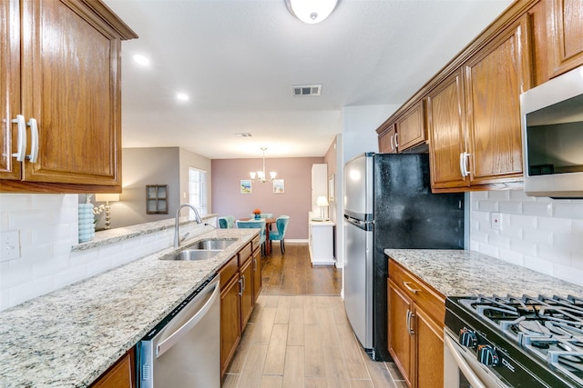 2019 Mcbroom St, Dallas, TX 75212 - kitchen with appliances with stainless steel finishes, brown cabinets, light stone countertops, and recessed lighting
