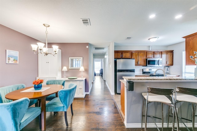 2019 Mcbroom St, Dallas, TX 75212 - kitchen with appliances with stainless steel finishes, brown cabinets, plenty of natural light, a breakfast bar, and recessed lighting
