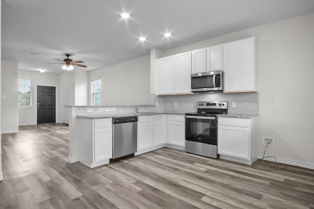 8313 White Pine Dr, Fort Worth, TX 76123 - kitchen featuring stainless steel appliances, backsplash, white cabinets, a peninsula, and recessed lighting