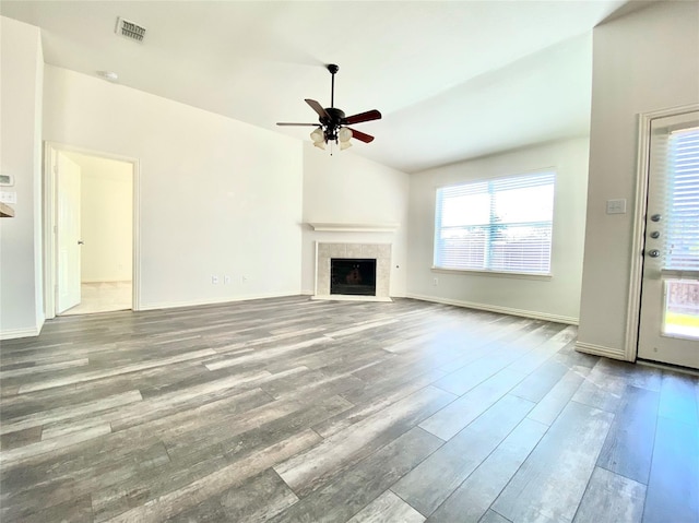2717 Lumina Dr, Little Elm, TX 75068 - unfurnished living room featuring wood finished floors, a ceiling fan, lofted ceiling, and a tiled fireplace