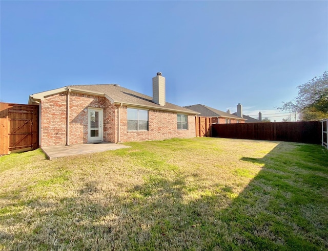 2717 Lumina Dr, Little Elm, TX 75068 - rear view of property with a fenced backyard, a chimney, brick siding, and a patio