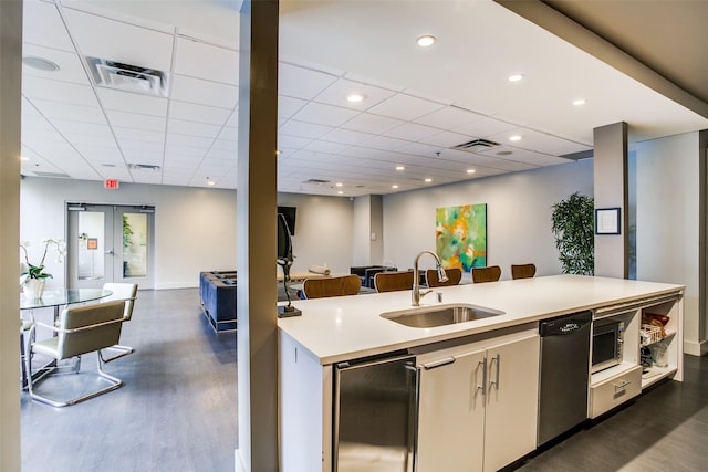 1200 Main St Unit 1402, Dallas, TX 75202 - kitchen with dark wood-type flooring, open floor plan, appliances with stainless steel finishes, and a paneled ceiling