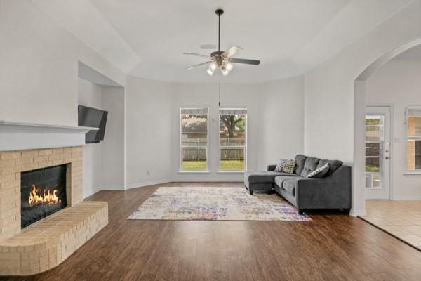 521 Willowview Dr, Saginaw, TX 76179 - living area with ceiling fan, arched walkways, wood finished floors, and a brick fireplace