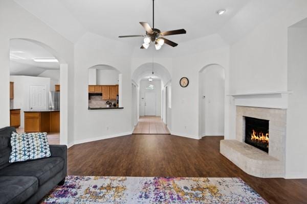 521 Willowview Dr, Saginaw, TX 76179 - living room with ceiling fan, a lit fireplace, wood finished floors, arched walkways, and vaulted ceiling