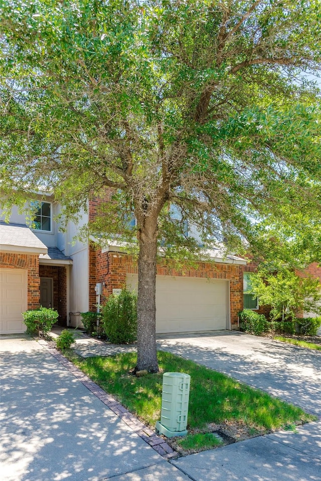 2142 Stonebrook Ln, Mesquite, TX 75181 - view of property hidden behind natural elements featuring driveway, brick siding, and a garage