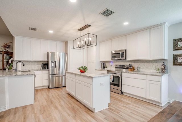 705 Tracy Dr, Azle, TX 76020 - kitchen featuring appliances with stainless steel finishes, tasteful backsplash, light wood-style flooring, light stone countertops, and recessed lighting