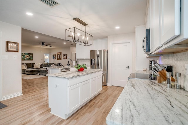 705 Tracy Dr, Azle, TX 76020 - kitchen with stainless steel appliances, open floor plan, backsplash, a kitchen island with sink, and ceiling fan
