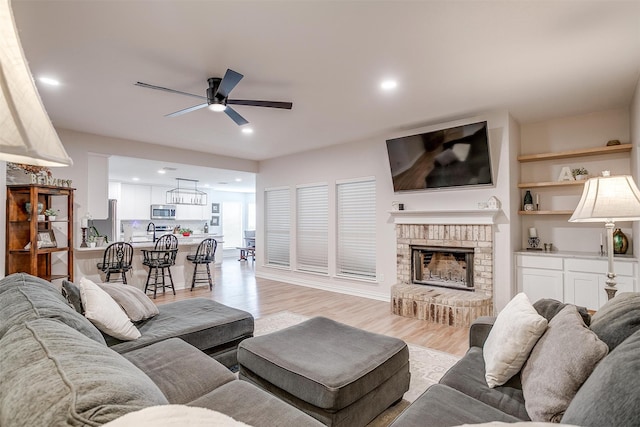 705 Tracy Dr, Azle, TX 76020 - living area with ceiling fan, light wood finished floors, a brick fireplace, and recessed lighting