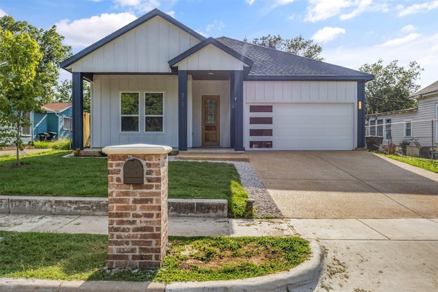 510 Woodrow Ave, Fort Worth, TX 76105 - view of front facade featuring a shingled roof, concrete driveway, an attached garage, a front lawn, and board and batten siding