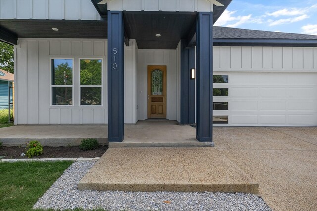 510 Woodrow Ave, Fort Worth, TX 76105 - property entrance featuring board and batten siding, an attached garage, a shingled roof, and concrete driveway