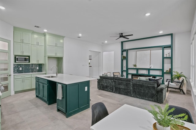 510 Woodrow Ave, Fort Worth, TX 76105 - kitchen with green cabinetry, stainless steel microwave, light countertops, decorative backsplash, and recessed lighting