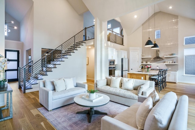 3915 Lochwood Dr, Rowlett, TX 75088 - living area featuring high vaulted ceiling, stairway, and light wood-style floors