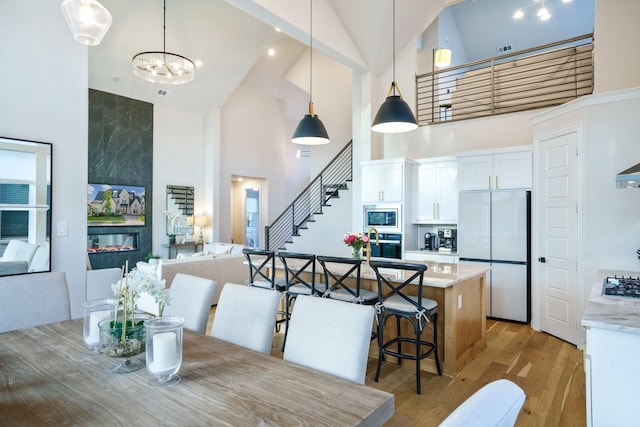 3915 Lochwood Dr, Rowlett, TX 75088 - dining space with high vaulted ceiling, light wood-style flooring, stairway, and a chandelier