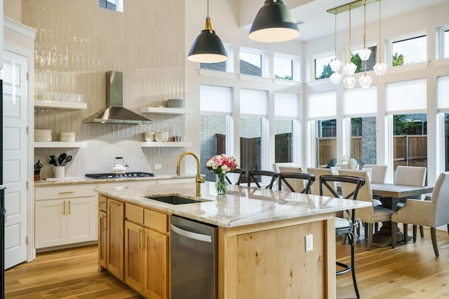 3915 Lochwood Dr, Rowlett, TX 75088 - kitchen with stainless steel appliances, wall chimney range hood, a kitchen bar, light wood-style floors, and a towering ceiling