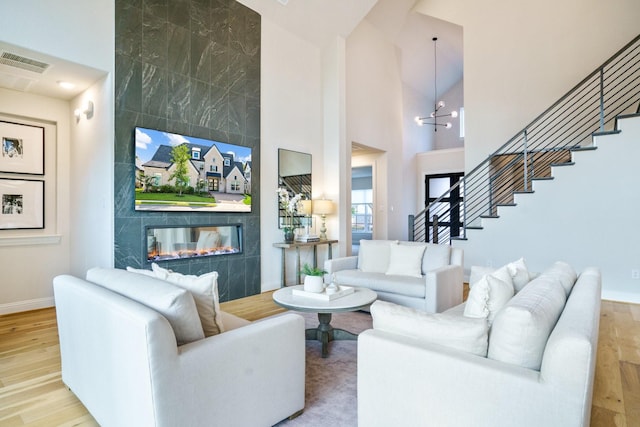 3915 Lochwood Dr, Rowlett, TX 75088 - living area with a high end fireplace, stairs, wood finished floors, and a towering ceiling