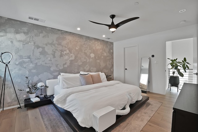 2001 N Prairie Ave Unit 106, Dallas, TX 75204 - bedroom with an accent wall, wallpapered walls, recessed lighting, light wood-type flooring, and ceiling fan