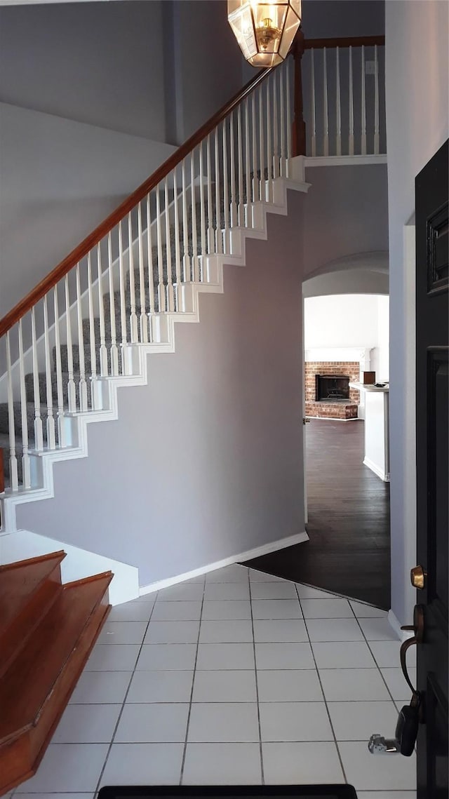 2017 Greenfield Ln, Allen, TX 75013 - staircase featuring tile patterned flooring, a fireplace, and a high ceiling