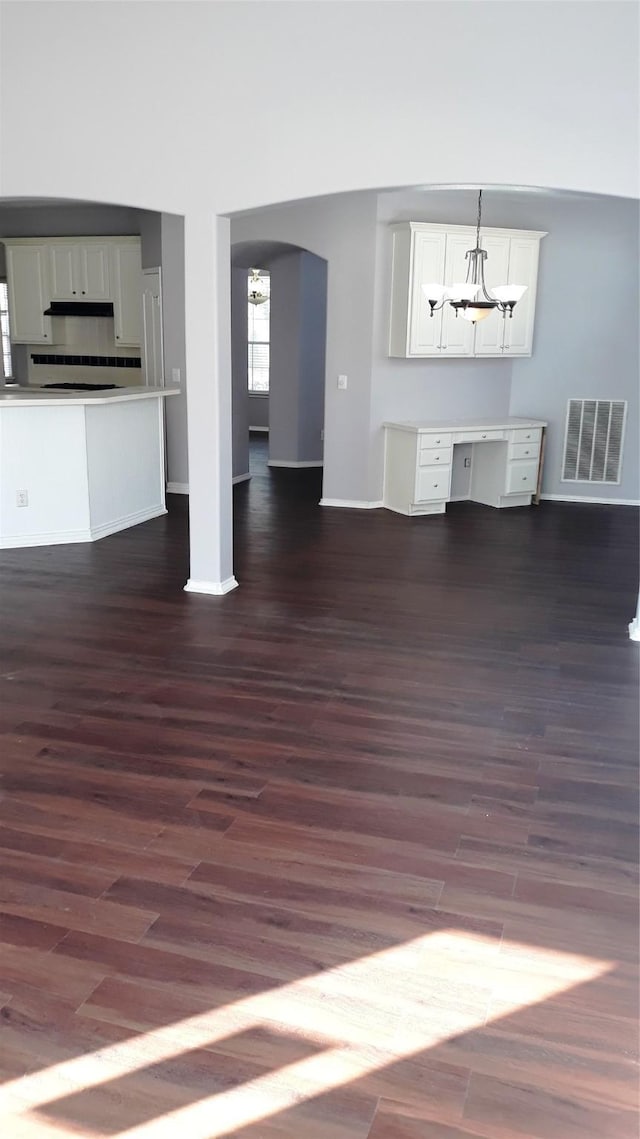 2017 Greenfield Ln, Allen, TX 75013 - unfurnished living room with dark wood finished floors, arched walkways, and a chandelier