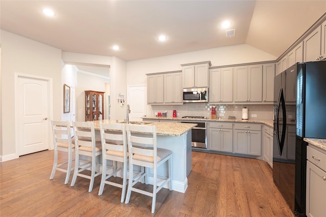 873 Mildren Ln, Fate, TX 75087 - kitchen with stainless steel microwave, range, freestanding refrigerator, gray cabinetry, and tasteful backsplash