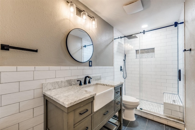 617 Ruth Dr, Kennedale, TX 76060 - bathroom with tile walls, vanity, a stall shower, tile patterned floors, and a textured wall