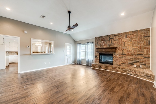 617 Ruth Dr, Kennedale, TX 76060 - unfurnished living room featuring a ceiling fan, lofted ceiling, wood finished floors, a brick fireplace, and recessed lighting