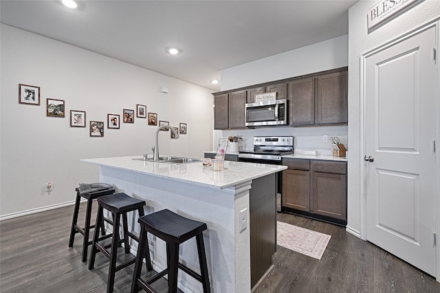 505 Cistern Way, Royse City, TX 75189 - kitchen with stainless steel appliances, dark wood-style floors, a breakfast bar, an island with sink, and dark brown cabinets