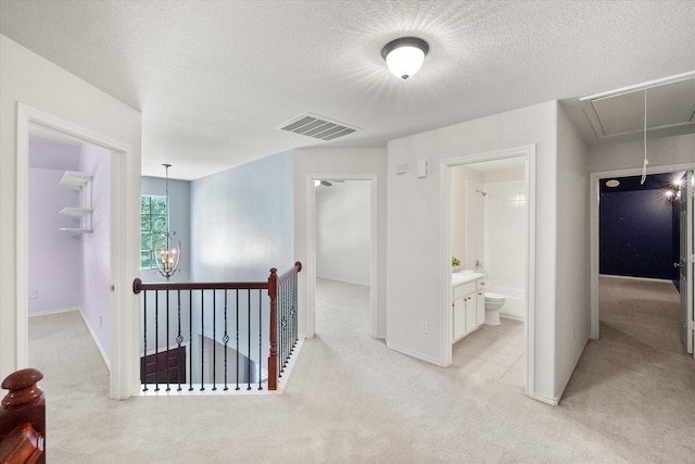 9324 Shadowfax Dr, Arlington, TX 76002 - hall with attic access, light colored carpet, an upstairs landing, a textured ceiling, and a chandelier