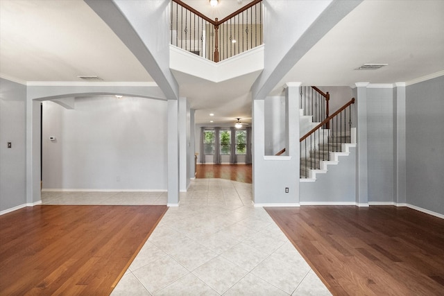 9324 Shadowfax Dr, Arlington, TX 76002 - tiled entrance foyer with arched walkways, stairs, crown molding, and a towering ceiling