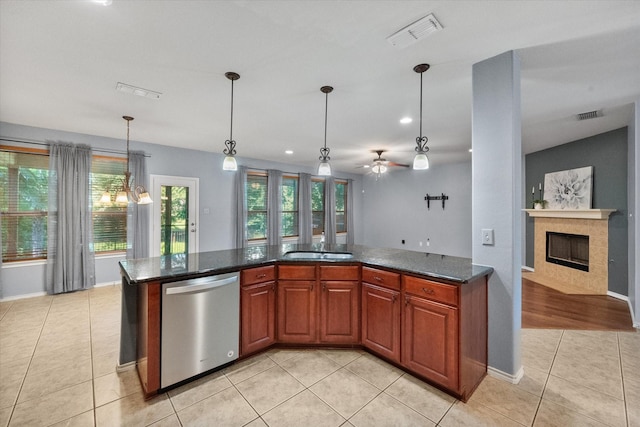 9324 Shadowfax Dr, Arlington, TX 76002 - kitchen featuring dishwasher, light tile patterned flooring, a tiled fireplace, pendant lighting, and a ceiling fan