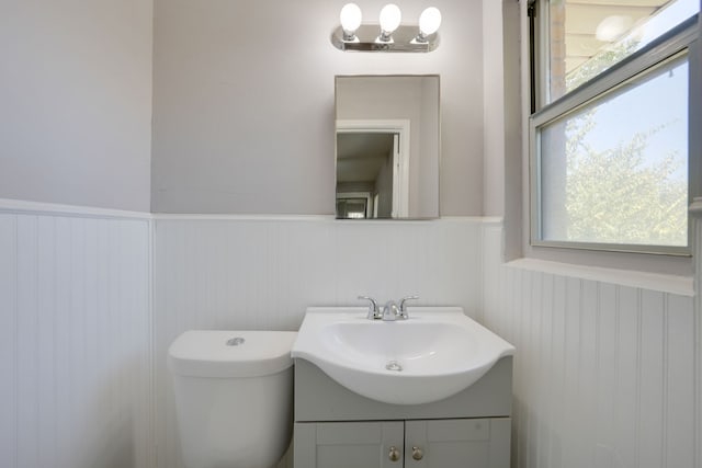 2442 Oates Dr, Dallas, TX 75228 - half bath featuring vanity, a wainscoted wall, and plenty of natural light