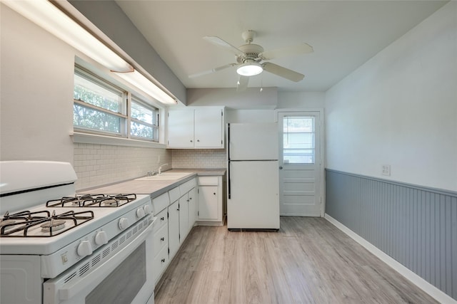 2442 Oates Dr, Dallas, TX 75228 - kitchen featuring white appliances, light wood-style flooring, plenty of natural light, light countertops, and a wainscoted wall