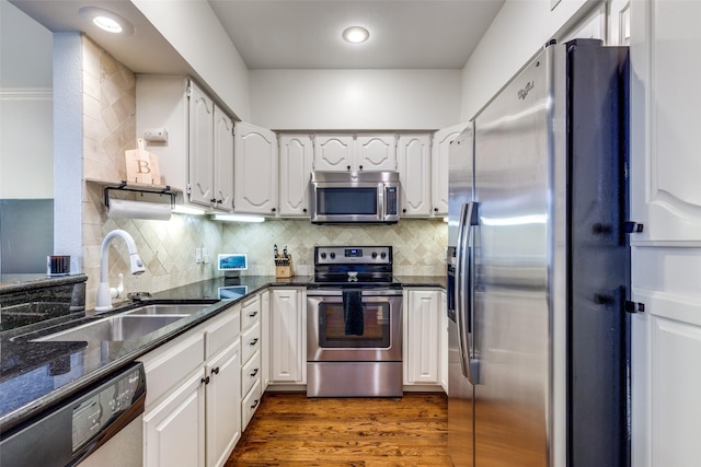 3208 Cole Ave Unit 1110, Dallas, TX 75204 - kitchen with stainless steel appliances, dark wood-style flooring, backsplash, white cabinetry, and dark stone counters