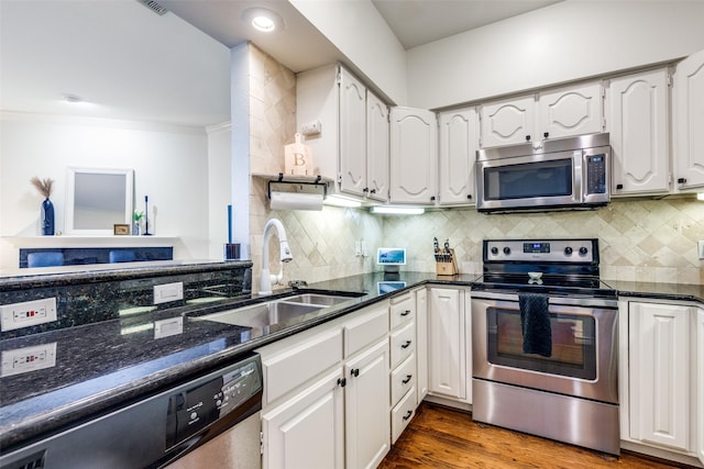 3208 Cole Ave Unit 1110, Dallas, TX 75204 - kitchen with appliances with stainless steel finishes, white cabinetry, backsplash, crown molding, and dark stone countertops