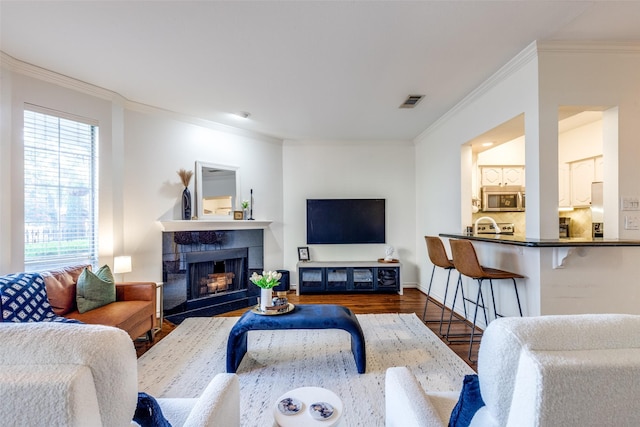 3208 Cole Ave Unit 1110, Dallas, TX 75204 - living area featuring wood finished floors, ornamental molding, and a fireplace