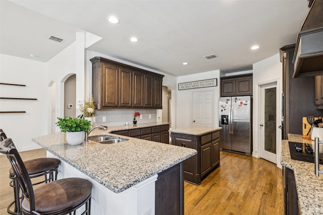 1344 Mountain View Ln, Kennedale, TX 76060 - kitchen featuring stainless steel refrigerator with ice dispenser, arched walkways, a peninsula, dark brown cabinets, and recessed lighting