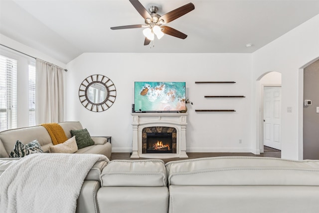 1344 Mountain View Ln, Kennedale, TX 76060 - living area featuring a ceiling fan, arched walkways, lofted ceiling, wood finished floors, and a warm lit fireplace