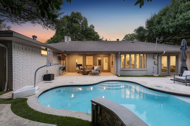 7339 Meadow Oaks Dr, Dallas, TX 75230 - pool at dusk featuring an outdoor living space, a patio, and an outdoor pool
