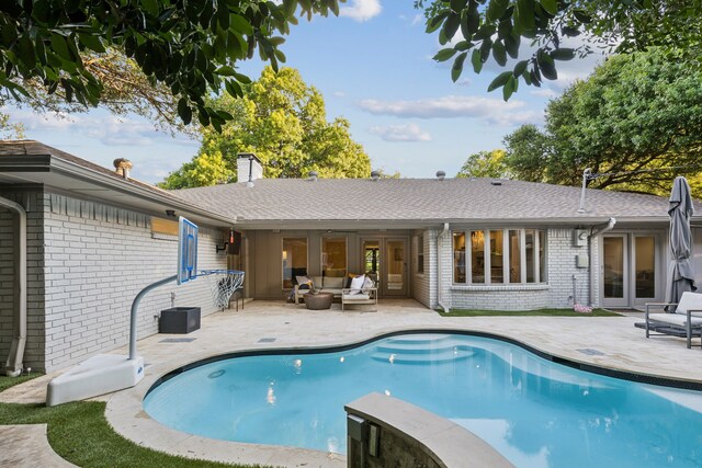 7339 Meadow Oaks Dr, Dallas, TX 75230 - back of house with brick siding, an outdoor living space, a patio, a chimney, and an outdoor pool