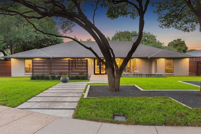 7339 Meadow Oaks Dr, Dallas, TX 75230 - view of front of home with brick siding, a front lawn, and a chimney