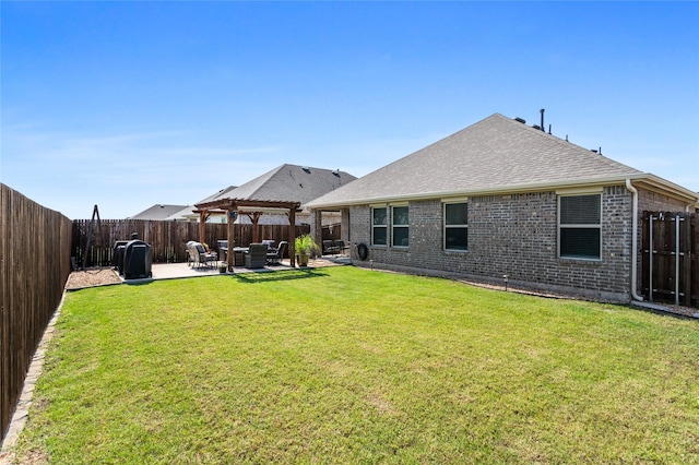 702 Stampede Ln, Princeton, TX 75407 - back of property featuring a patio area, brick siding, a fenced backyard, and roof with shingles