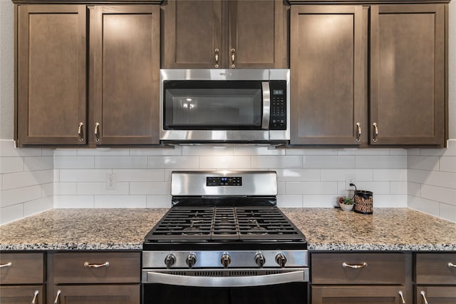 702 Stampede Ln, Princeton, TX 75407 - kitchen with stainless steel appliances, dark brown cabinetry, and decorative backsplash