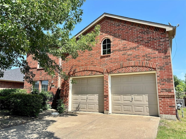 150 Wandering Dr, Forney, TX 75126 - view of front facade featuring driveway, brick siding, and an attached garage
