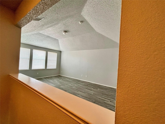 150 Wandering Dr, Forney, TX 75126 - bonus room with a textured wall, wood finished floors, a textured ceiling, and vaulted ceiling